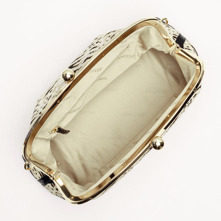 Interior view of the Brahmin Christine handbag showing a beige fabric-lined main compartment with gold-tone hardware and a black and white textured pattern exterior.