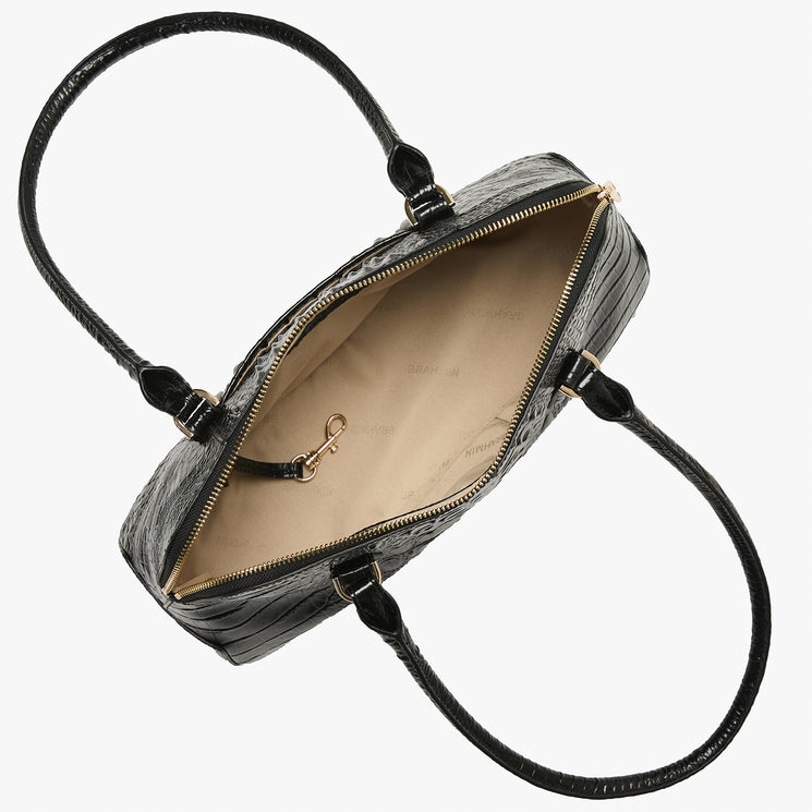 An open black crocodile-embossed handbag with a beige interior lining and gold-tone hardware, shown from a top-down angle on a white background. Open top view.