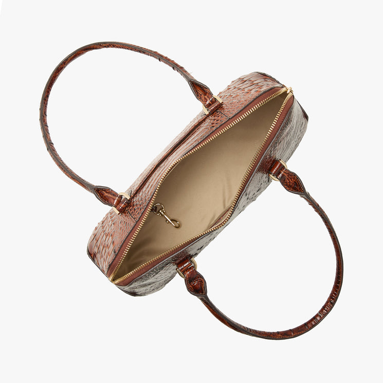 A brown crocodile-embossed handbag with a gold zipper and handles, shown open against a light gray background. Open top view.