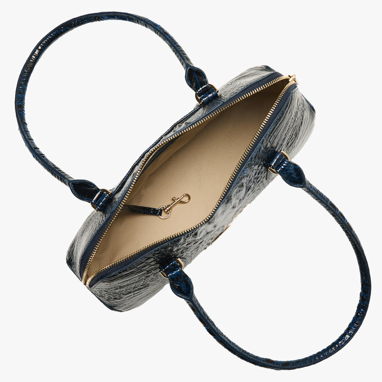 A top-down view of a textured navy blue handbag with a gold zipper and a beige interior, shown on a plain white background. Open top view.