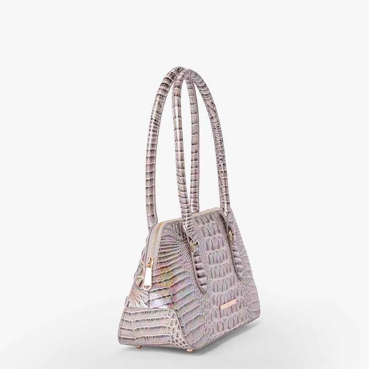 Brahmin small structured handbag in pale lavender with shiny crocodile-embossed texture, gold-tone zipper and dual top handles, displayed against a white background. Perfect for hand or arm carry.