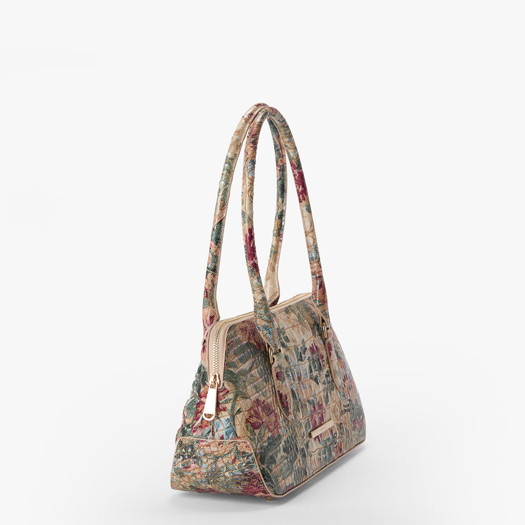 A structured handbag with a vintage floral tapestry pattern in muted red, green, and beige tones, featuring dual top handles and a gold-tone zipper closure, shown against a plain white background.