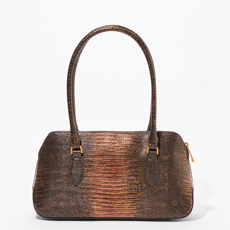 A structured handbag with a textured reptile pattern in metallic bronze and brown, featuring dual top handles and gold-tone hardware, photographed against a clean white background.