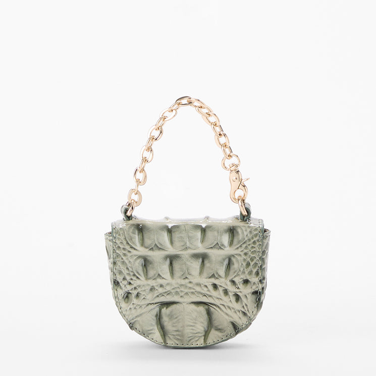 A small structured coin purse with a textured crocodile skin pattern in a muted sage green, featuring a gold-tone chain handle and clasp, set against a plain white background.