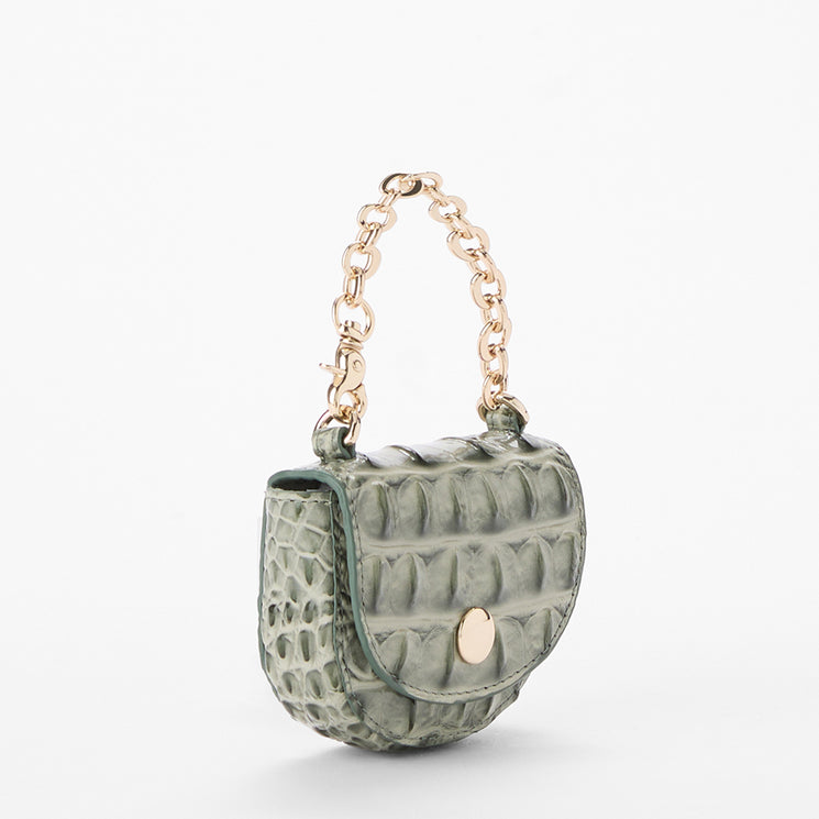 A small green crocodile-embossed leather coin purse with a gold-tone chain handle and snap closure, shown on a clean white background.