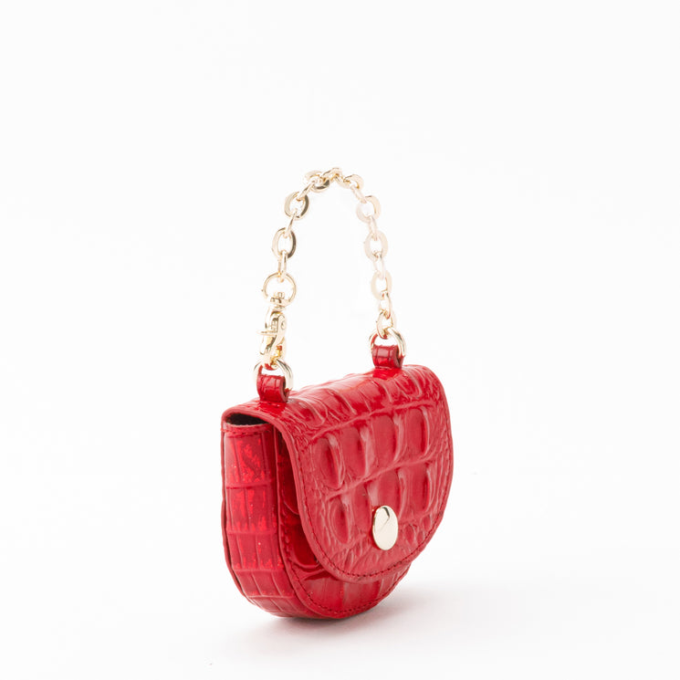 Small holiday red Brahmin Joy Pouch with a textured, embossed finish, featuring a flap closure, gold-tone button hardware, and a matching gold-tone chain handle.