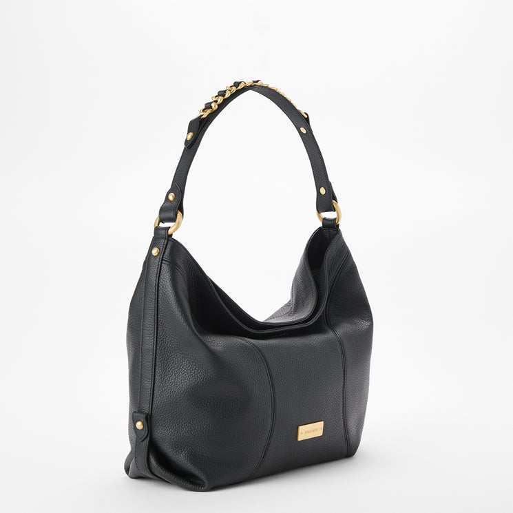 Brahmin black handbag with a wide shoulder strap, gold-tone hardware and studs, textured surface, and small gold logo plate on the front. Shown against a white background.