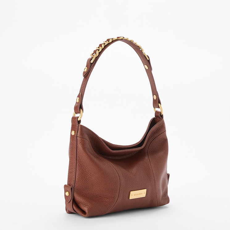 Brahmin brown handbag with a single shoulder strap featuring gold chain links and accents, a slouched silhouette, textured surface, gold rectangular logo plate on the front, shown from the front view.