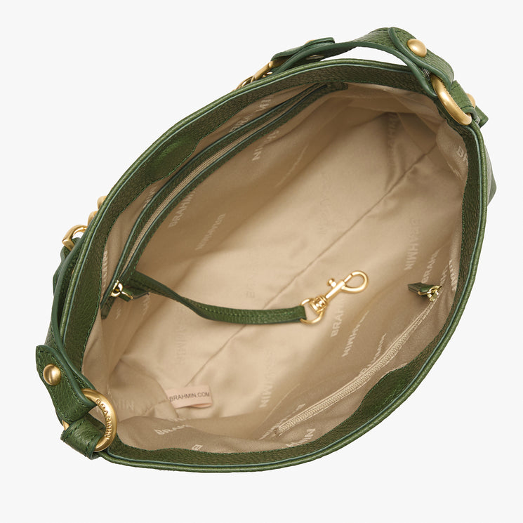 An overhead view of a green leather handbag interior, showing a beige patterned lining, zippered compartments, and gold-tone hardware on a white background.