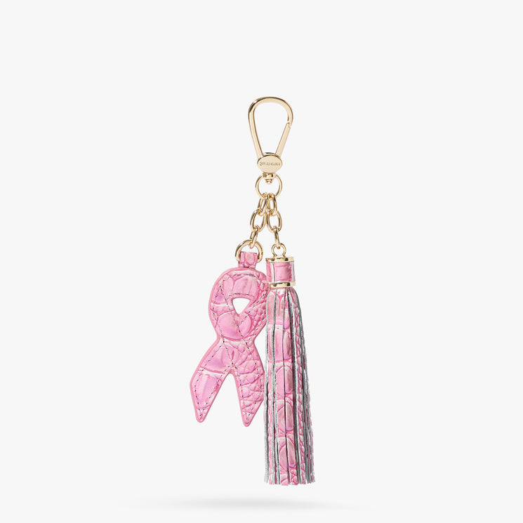 Brahmin gold keychain featuring a visible pink ribbon charm and matching pink-and-gold tassel, displayed on a white background; hardware is shiny gold-tone with textured details, ideal for accessorizing bags.