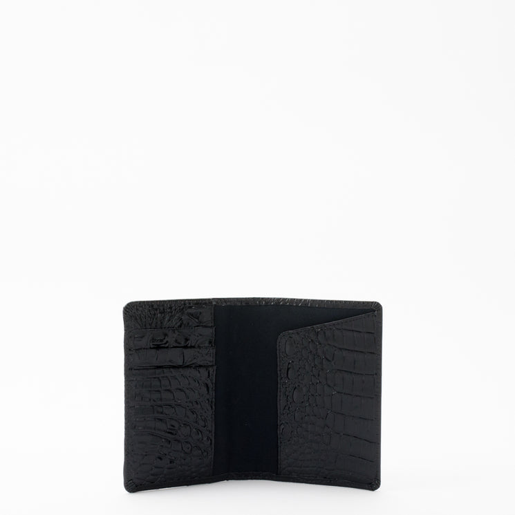BRAHMIN Travel Pouch Set in black with embossed, crocodile-inspired texture, open and empty. Features structured silhouette, zip closure, and branded hardware against a white background.