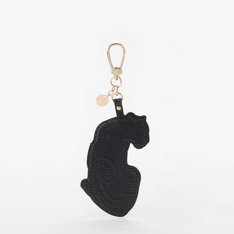 Brahmin black keychain in a cat silhouette, featuring smooth texture, gold-tone clasp hardware, and a small round gold tag. Shown against a plain white background.