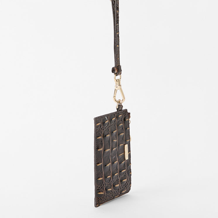 A dark brown crocodile-embossed leather pouch with a matching wrist strap and gold-tone hardware, shown against a plain light gray background. Side view.