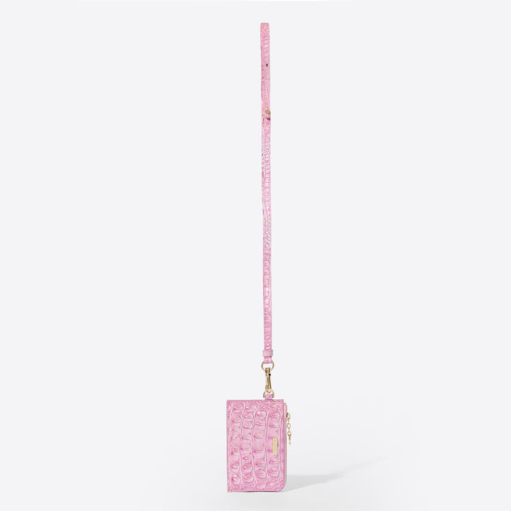 Brahmin pink crossbody bag with embossed texture, gold-tone hardware, and a long matching adjustable strap, shown upright against a plain white background. Compact silhouette with flap closure visible.