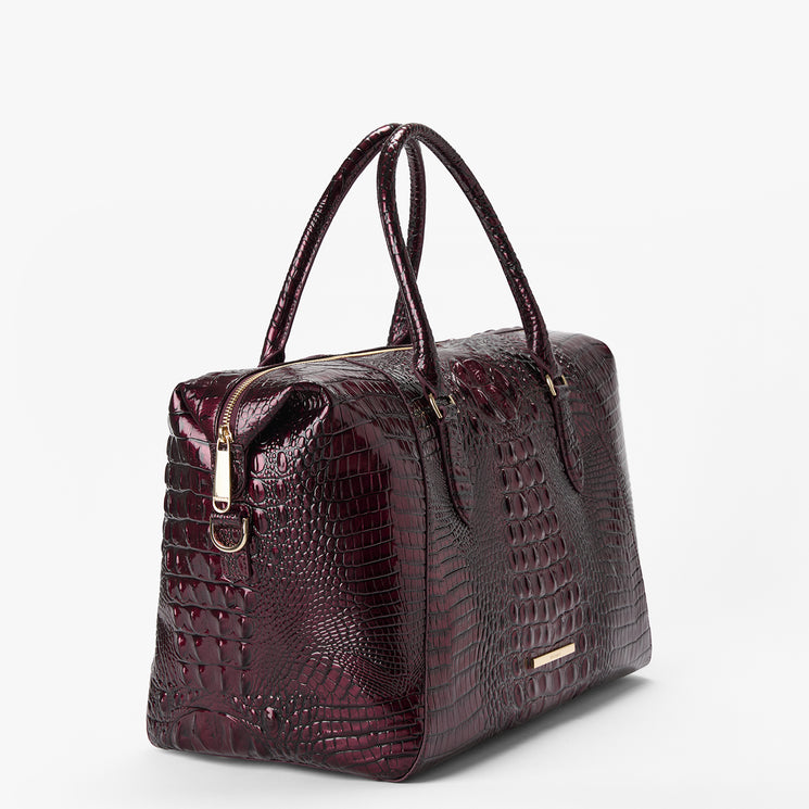 A dark burgundy crocodile-embossed leather handbag with dual top handles and gold-tone hardware, photographed on a clean white background.