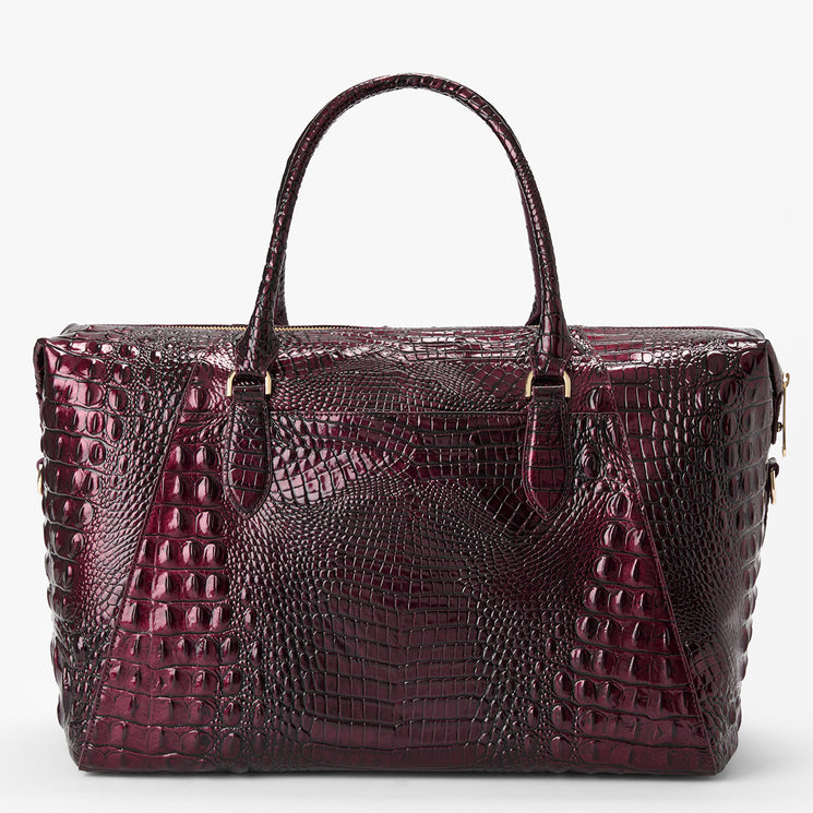 A structured satchel handbag with a glossy, embossed crocodile pattern in deep burgundy, featuring dual top handles and gold-tone hardware, set against a plain light gray background.