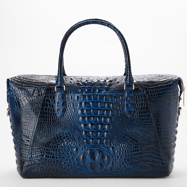 The back of a dark blue crocodile-embossed leather handbag with double top handles and gold-tone hardware, photographed against a clean white background.