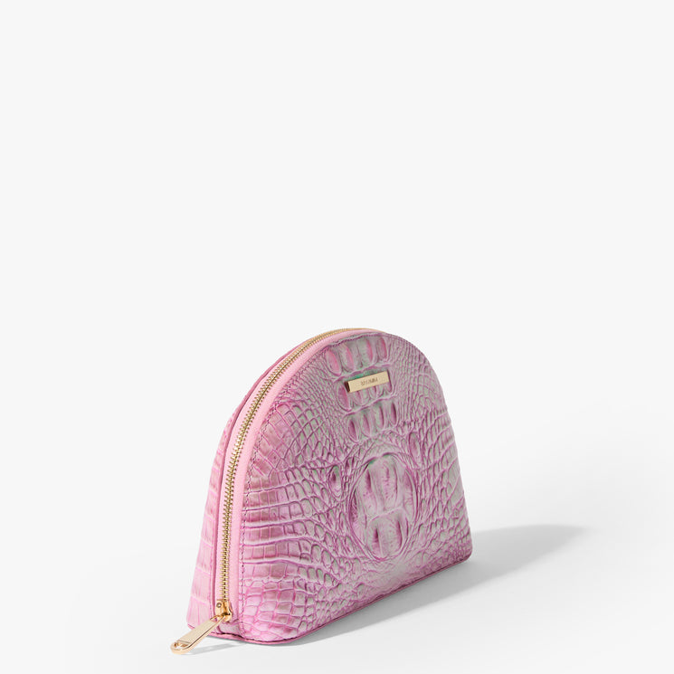 Brahmin pink semi-circular cosmetic bag with embossed textured pattern, gold zipper closure, and gold nameplate branding shown upright on a white background. No strap or interior is visible.