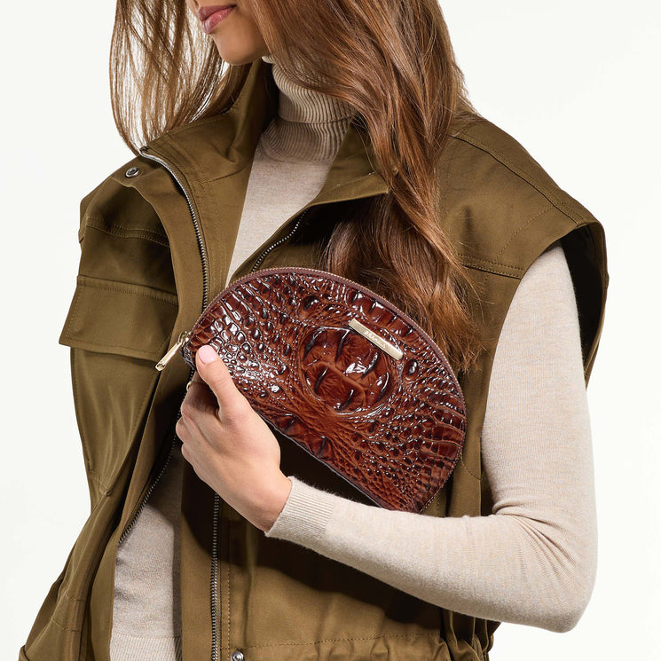 Woman holding Marna clutch bag against a neutral background