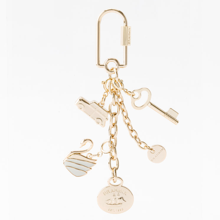 Brahmin Small Swan gold-tone keychain featuring a carabiner clip and five charms: a car, a key, a swan with white inlay, a circular logo disc, and a round medallion embossed with a sailboat.