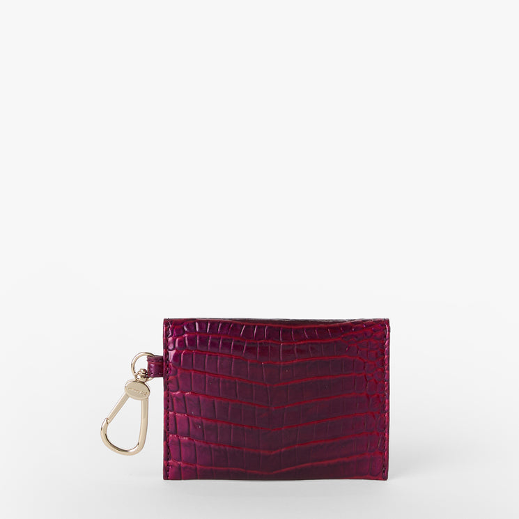 BRAHMIN Lana small square wallet in dark red with embossed, textured pattern, features a left key clip and gold-tone hardware. Shown against a white background, highlighting its compact silhouette and vivid color.