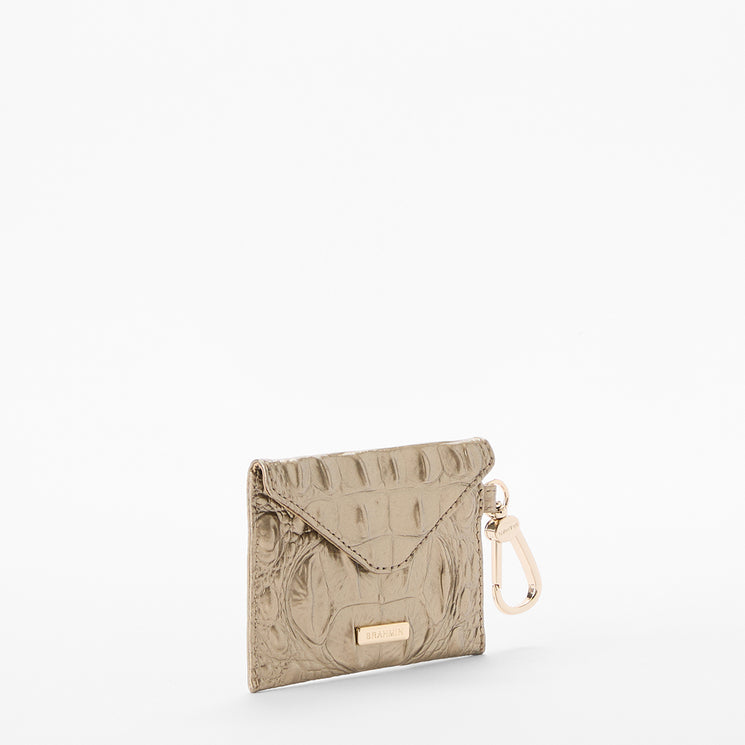 BRAHMIN Lana cardholder in taupe with textured finish, flap closure, gold-tone Dune plaque, and attached key clip. Compact rectangular silhouette displayed on a white background.