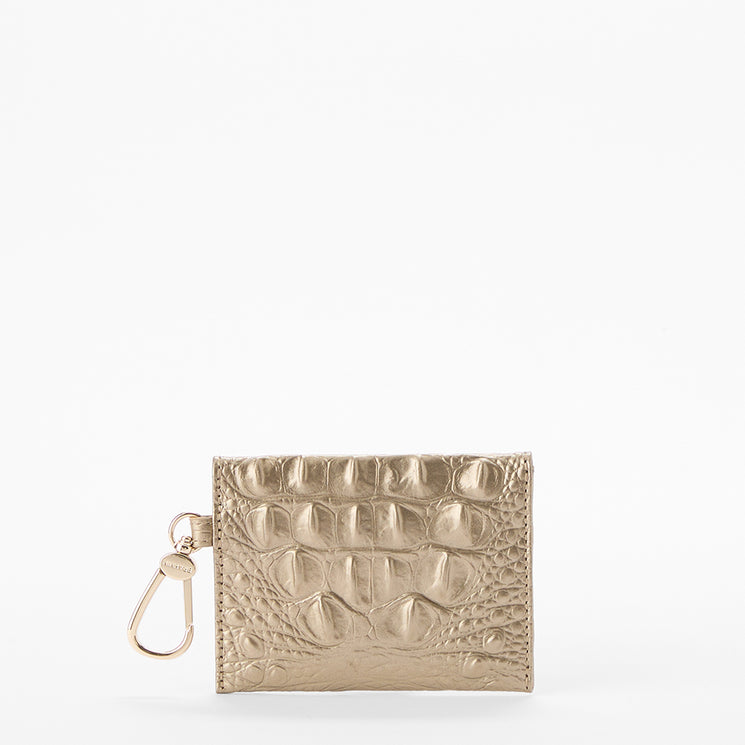 BRAHMIN Lana gold square wallet with embossed texture, zipper closure, left-side key clip, and metallic hardware, shown against a white background. Distinctive silhouette highlights the shimmering gold finish.