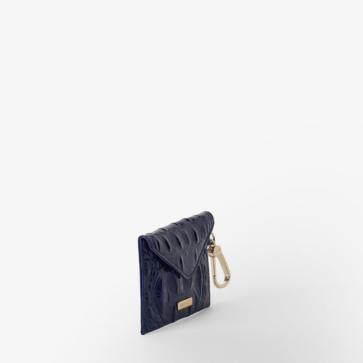 BRAHMIN Lana small pouch in midnight blue quilted leather, featuring gold-tone clasp and keyring hardware. Compact silhouette, visible stitched diamond pattern, shown as a clip-on accessory for handbags.