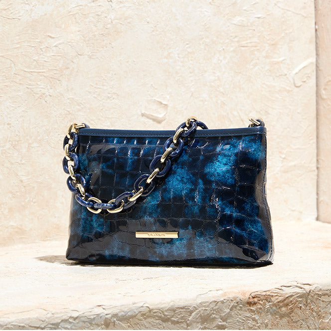 Deep blue patent croc embossed Brahmin shoulder bag with chunky chain strap and polished gold logo hardware.