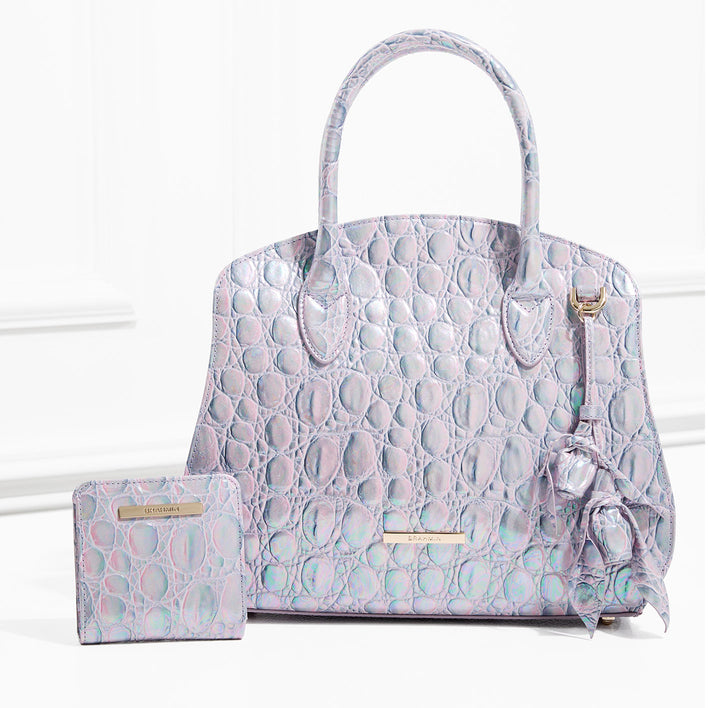 Iridescent lavender croc-embossed leather satchel with top handles, detachable strap hardware, logo nameplate, and matching wallet with gold-tone bar detail