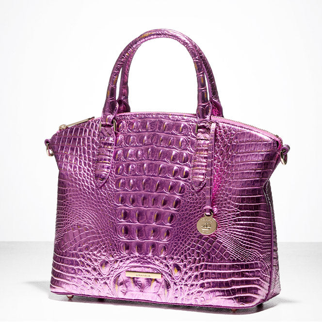 Purple metallic croc-embossed Brahmin satchel with top handles and gold hardware, photographed on a clean white background.