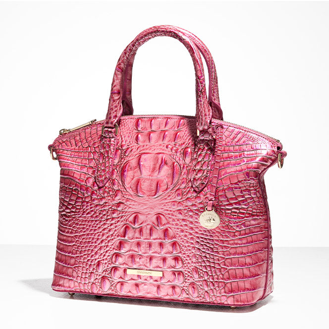 Hot pink croc-embossed leather satchel handbag with structured silhouette, zip-top closure, rolled top handles, gold-tone nameplate, and round hangtag charm