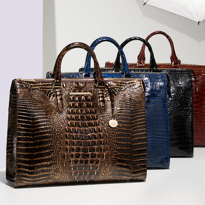 Brahmin structured handbag collection in brown, blue, black and red with glossy embossed texture, double top handles, zip closures and gold tone hardware.