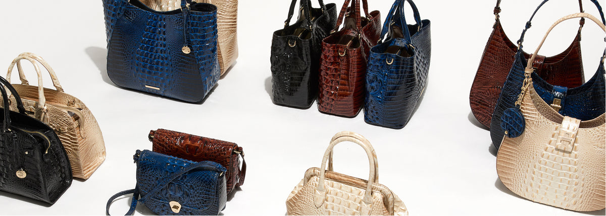 Brahmin wholesale handbag collection featuring croc embossed leather totes, satchels, hobos, shoulder bags, and crossbody bags in glossy sapphire blue, black, pecan brown, and ivory with gold hardware on a white studio background.