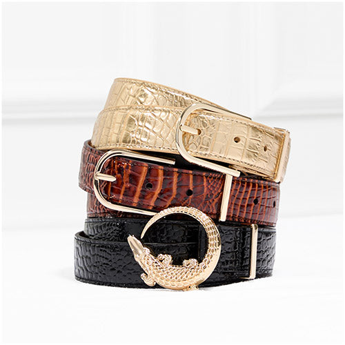 Stacked Brahmin leather belts in gold, brown, and black croc textures, showcasing metallic buckles and signature craftsmanship.