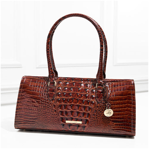Cognac brown croc-embossed leather shoulder tote with long straps, structured rectangular silhouette, gold-tone logo bar, and round hangtag charm
