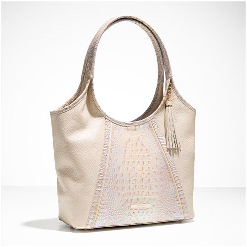 Cream leather shoulder tote with iridescent croc-embossed center panel, contrast shoulder straps, and side tassel detail on a white background