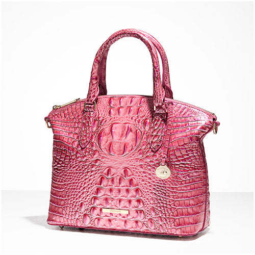 Hot pink croc-embossed structured satchel with zip-top closure, rolled top handles, gold-tone logo bar, and round hangtag charm on a white background
