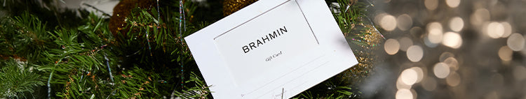 Brahmin gift card displayed on a Christmas tree with festive holiday lights in the background.
