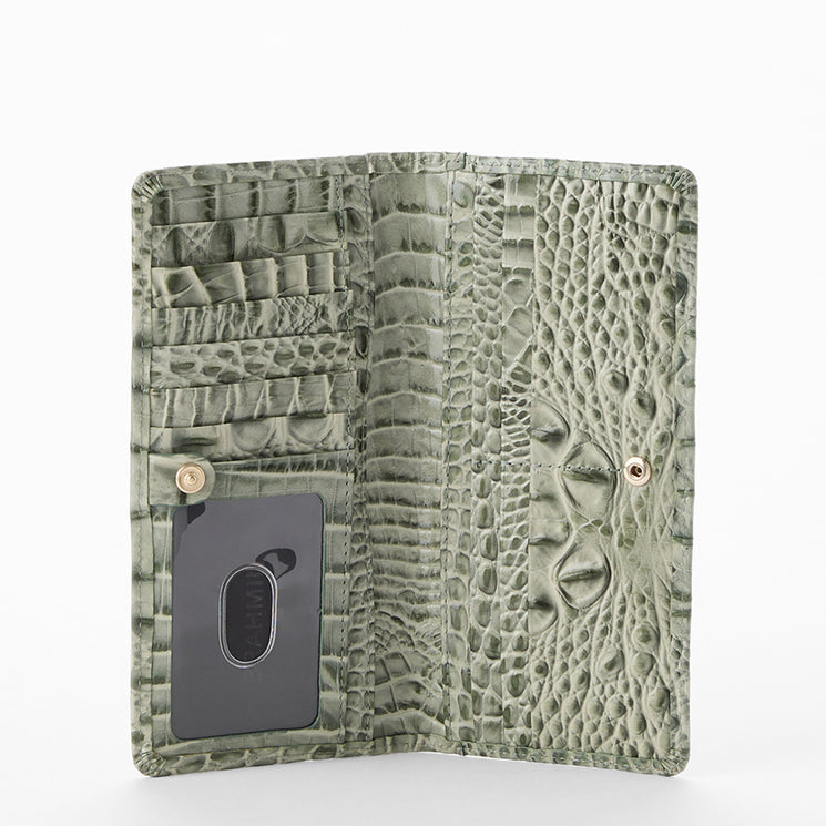 A sage green crocodile-embossed wallet shown open against a clean white background, featuring multiple card slots, a central ID window, and a textured pattern.