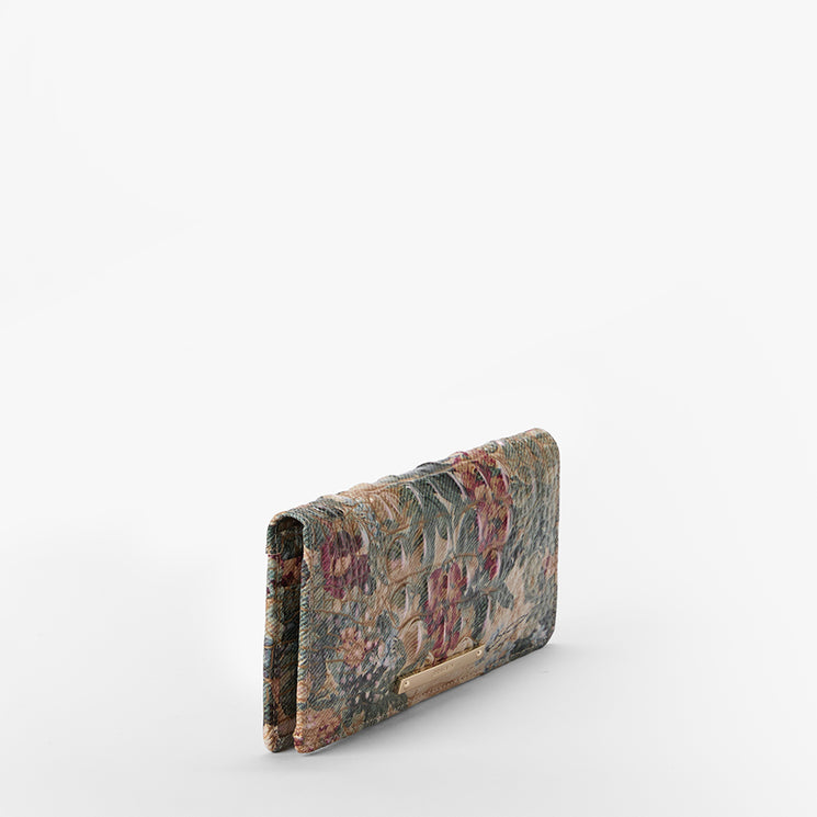 A textured wallet with a multicolor floral and croc pattern in earthy tones, shown on a clean white background.