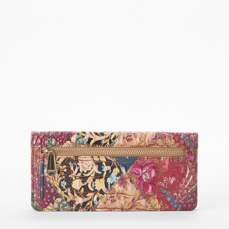 Brahmin patchwork floral wallet with vibrant colors, front zipper pocket, gold-tone zipper pull, and compact silhouette shown against a white background.