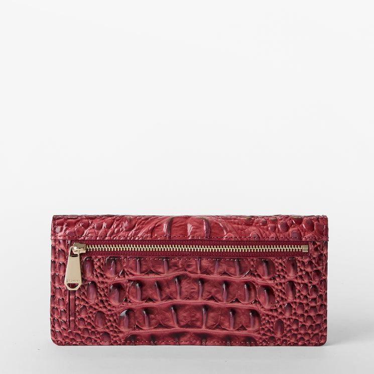 Brahmin red embossed leather clutch with textured pattern, gold-tone front zipper pocket, rectangular shape, and sleek silhouette. Shown flat against a white background; no strap or interior details visible.