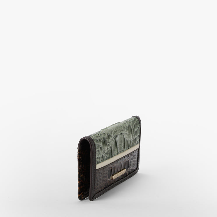 A slim wallet featuring a textured green alligator skin flap and a dark brown crocodile skin body, with a beige leather band and a small gold-tone metal clasp, shown on a plain white background.