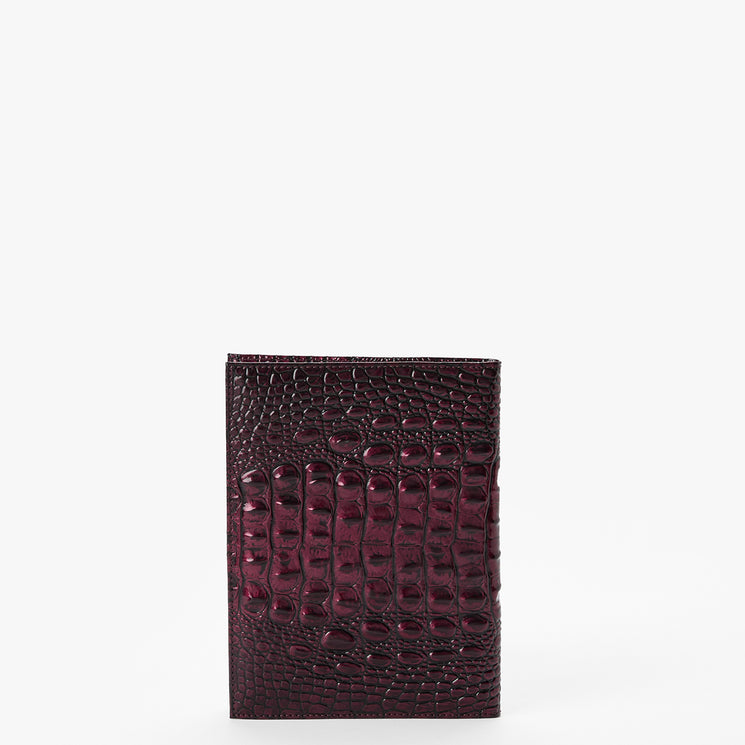 A dark burgundy crocodile-embossed leather wallet standing vertically against a plain white background.