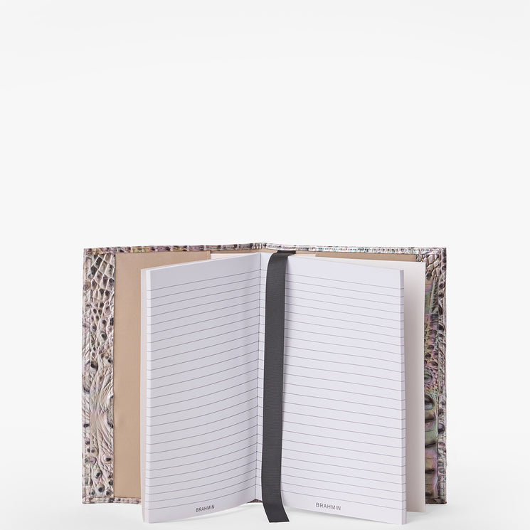 Brahmin textured light beige notebook with black ribbon bookmark, open and standing upright on a white background. Features lined pages and minimalist, elegant design—ideal for gifting or everyday use.