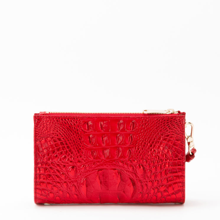Bright red Brahmin Daisy wristlet with a glossy, embossed textured pattern, featuring a gold-tone top zipper and a side clip.