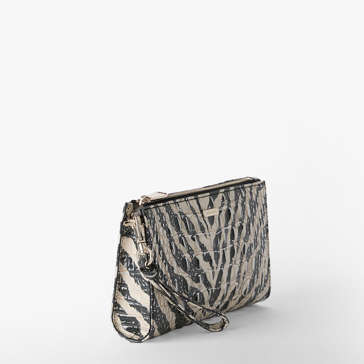 Brahmin clutch bag featuring a black and beige textured animal-inspired pattern, gold-tone zipper closure, and wrist strap, shown on a plain white background. Compact silhouette designed for hand or wrist carry.