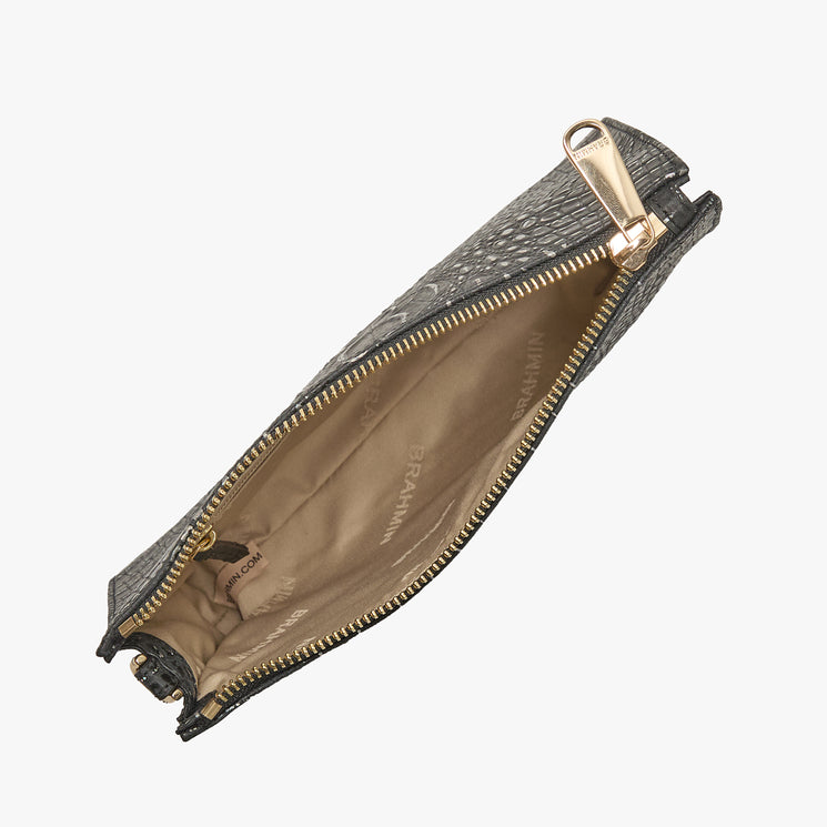 Brahmin gray textured zippered clutch purse, partially unzipped to reveal beige fabric interior with Brahmin logo, gold-tone zipper, and attached key clip. Elegant silhouette shown in angled view.
