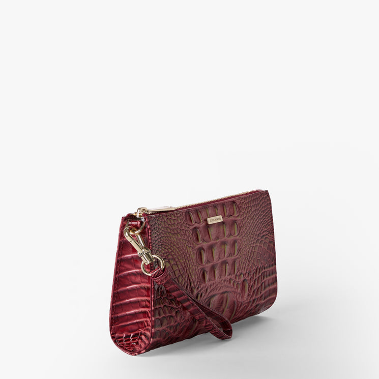 Brahmin maroon embossed clutch with wrist strap, gold-tone hardware, and textured finish, shown on a plain white background. Sleek rectangular silhouette highlights signature Brahmin design details.